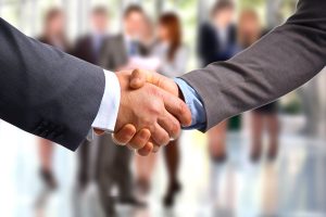 a close up of two people shaking hands.